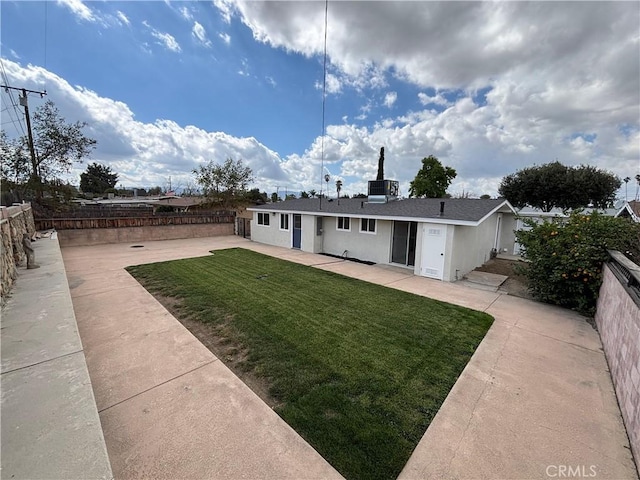 back of house featuring fence private yard, a patio area, and a lawn