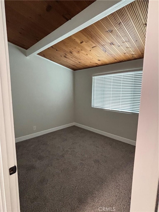 empty room featuring beamed ceiling, carpet, wood ceiling, and baseboards