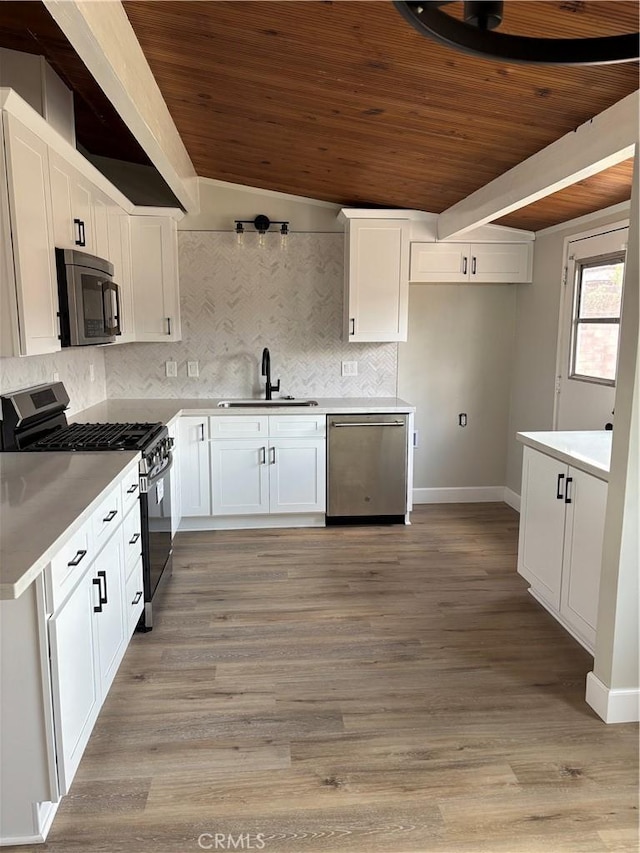 kitchen with wood ceiling, appliances with stainless steel finishes, decorative backsplash, and a sink