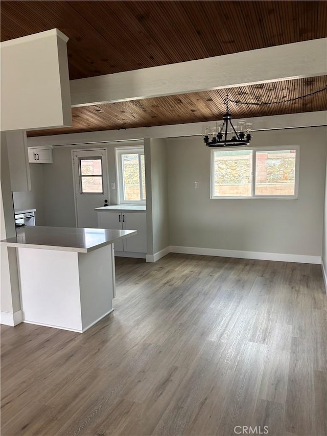 kitchen featuring a notable chandelier, baseboards, and wood finished floors