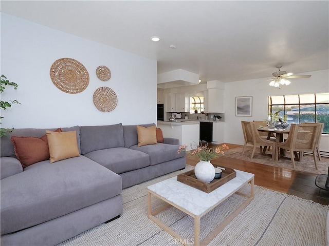 living room with a healthy amount of sunlight, light wood-style floors, and a ceiling fan