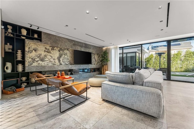 living area with expansive windows, rail lighting, an accent wall, and recessed lighting