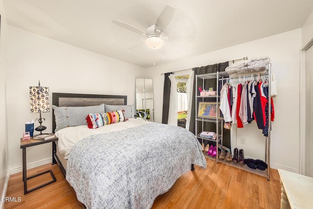 bedroom featuring baseboards, light wood finished floors, and ceiling fan