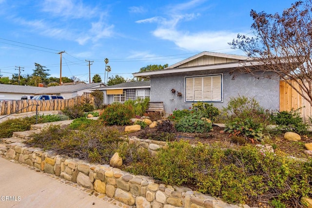 ranch-style home with stucco siding and fence