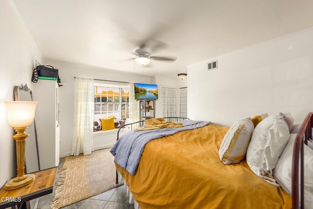 tiled bedroom with visible vents and a ceiling fan