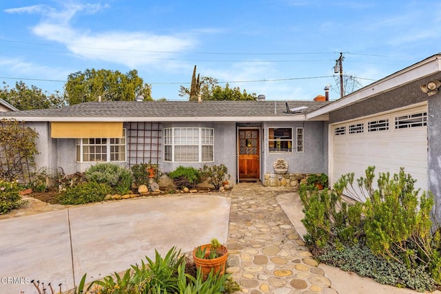 ranch-style house with stucco siding, a shingled roof, and a garage