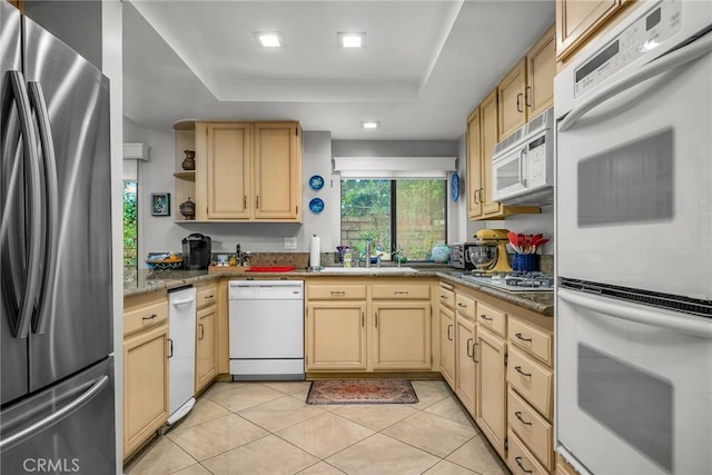 kitchen with white appliances, light tile patterned floors, a raised ceiling, open shelves, and a sink