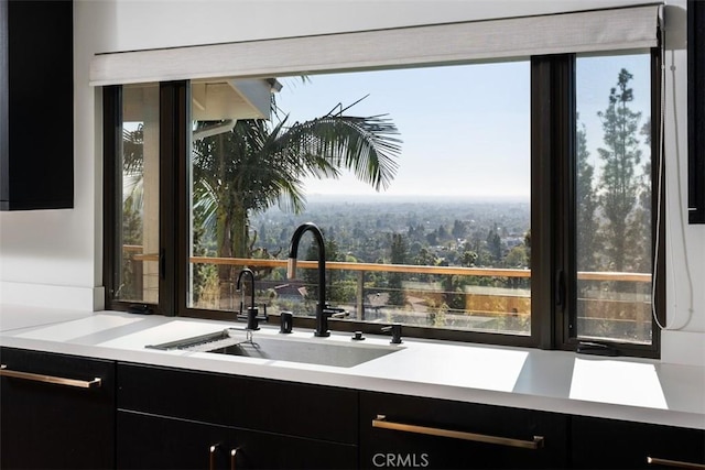 10831 Hideaway Dr, North Tustin, CA 92705 - kitchen with light countertops, dark cabinets, a sink, and modern cabinets
