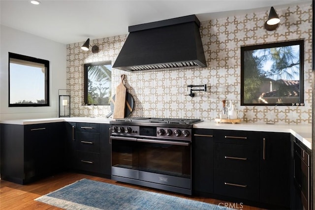 10831 Hideaway Dr, North Tustin, CA 92705 - kitchen featuring high end stainless steel range, light countertops, dark cabinets, light wood-style flooring, and premium range hood