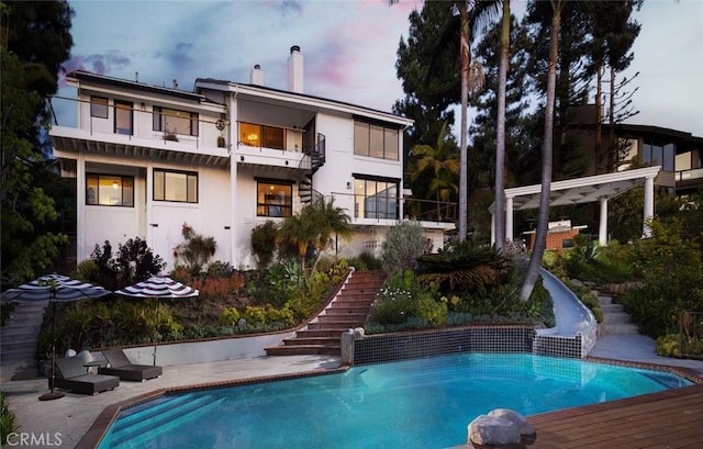 10831 Hideaway Dr, North Tustin, CA 92705 - rear view of house featuring an outdoor pool, a chimney, stairway, and a balcony