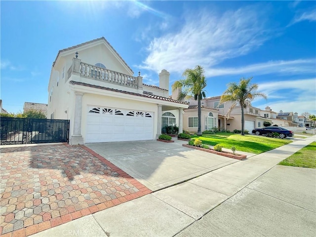 view of front of house with stucco siding, an attached garage, fence, a balcony, and driveway