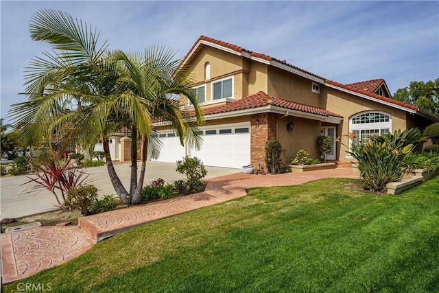 mediterranean / spanish home featuring an attached garage, stucco siding, concrete driveway, a front lawn, and a tiled roof