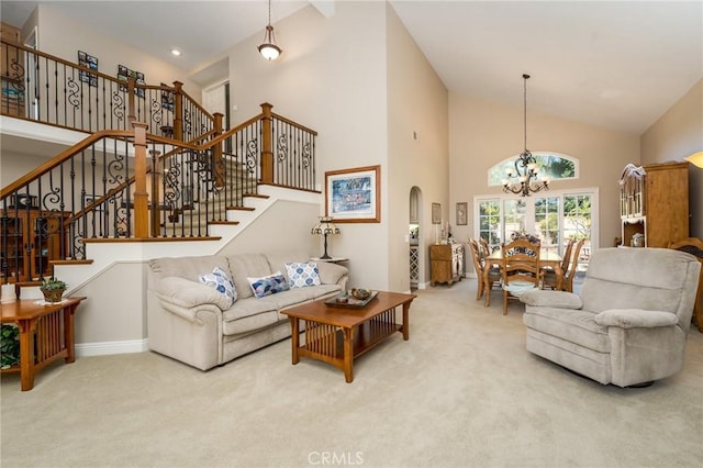 23 Landing, Laguna Niguel, CA 92677 - carpeted living room with high vaulted ceiling, a chandelier, stairs, and arched walkways