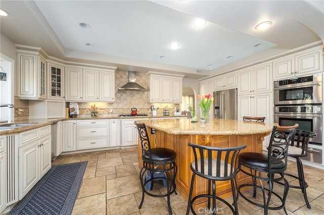 23 Landing, Laguna Niguel, CA 92677 - kitchen featuring stainless steel appliances, wall chimney exhaust hood, a kitchen island, decorative backsplash, and a kitchen breakfast bar
