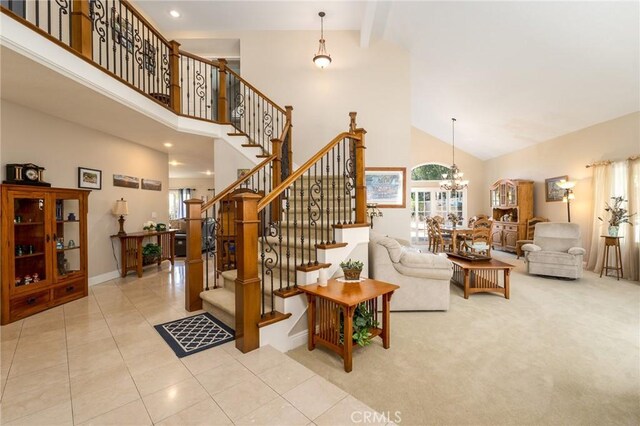 23 Landing, Laguna Niguel, CA 92677 - tiled living room featuring high vaulted ceiling, healthy amount of natural light, stairway, a chandelier, and carpet flooring