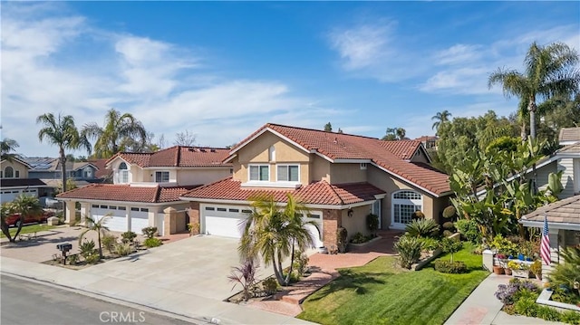 23 Landing, Laguna Niguel, CA 92677 - mediterranean / spanish-style house featuring driveway, stucco siding, a tiled roof, an attached garage, and a front lawn