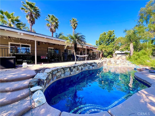 outdoor pool with fence and a patio