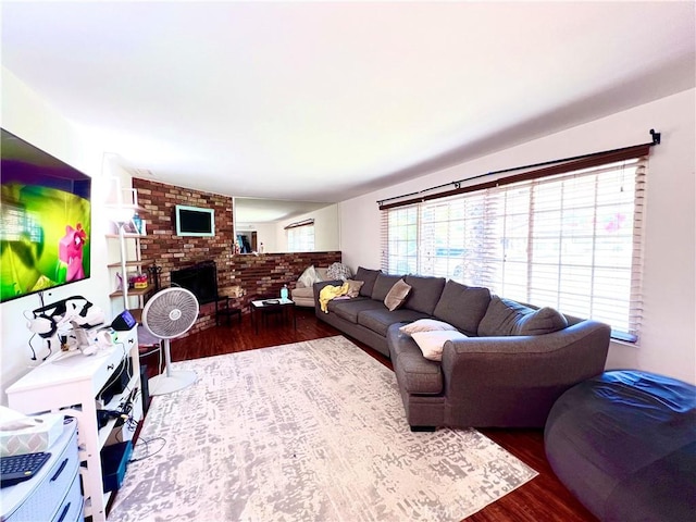 living room with a fireplace, wood finished floors, and a healthy amount of sunlight