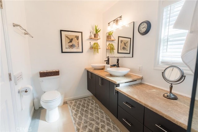 bathroom featuring toilet, tile patterned floors, vanity, and baseboards