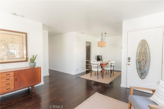 foyer entrance featuring dark wood-style flooring, visible vents, and baseboards