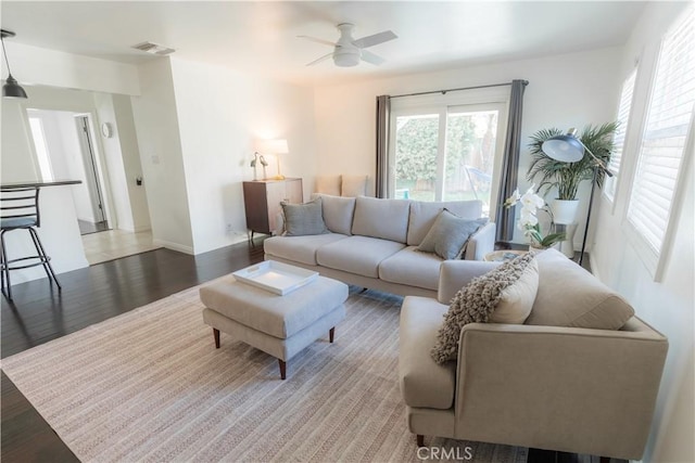 living room featuring visible vents, ceiling fan, and light wood-style flooring