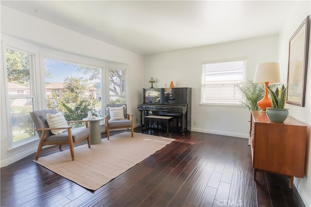 sitting room with dark wood-type flooring and baseboards