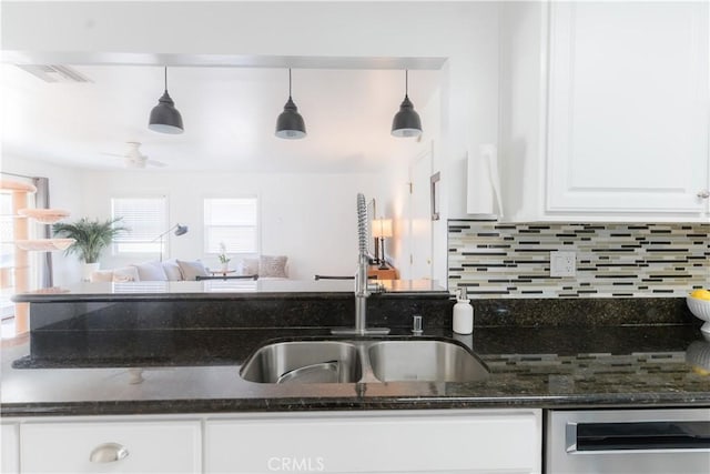 kitchen with a sink, white cabinetry, backsplash, dark stone counters, and dishwasher