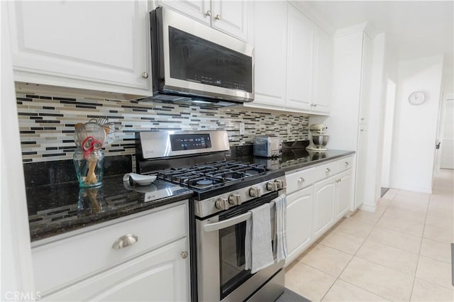 kitchen with light tile patterned floors, white cabinetry, stainless steel appliances, and backsplash