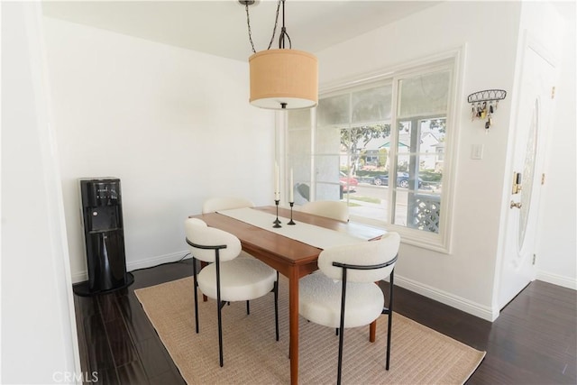 dining area with dark wood-type flooring and baseboards