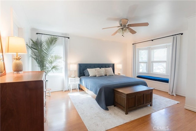 bedroom featuring ceiling fan, light wood-style flooring, and baseboards