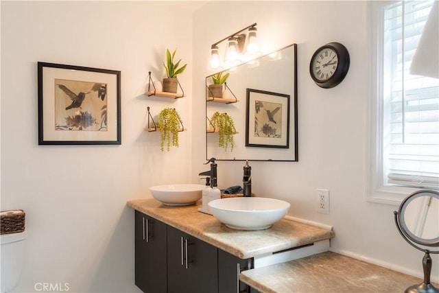 full bathroom with plenty of natural light, a sink, and double vanity