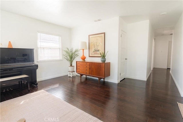 living area featuring visible vents, wood finished floors, attic access, and baseboards