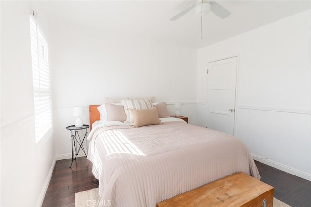 bedroom featuring ceiling fan, baseboards, and wood finished floors