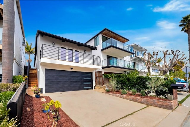 modern home featuring driveway, a garage, stairway, a balcony, and stucco siding
