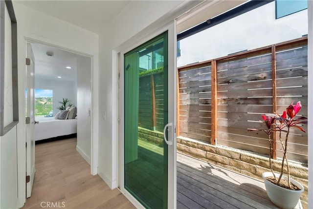 doorway featuring baseboards, recessed lighting, and light wood-style flooring