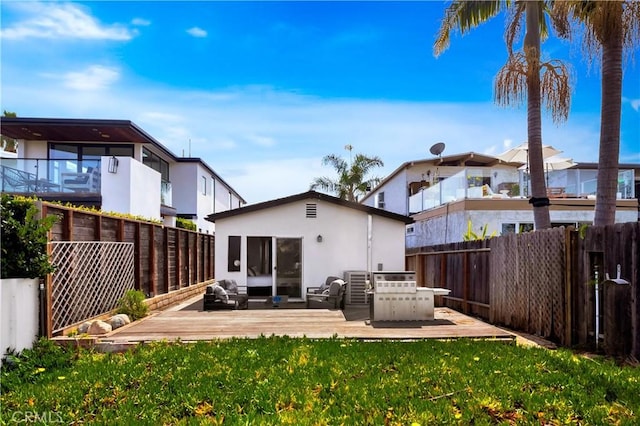 back of property with a yard, a fenced backyard, and a wooden deck