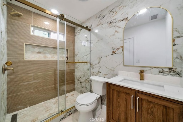 full bath featuring toilet, visible vents, vanity, tile walls, and a stall shower