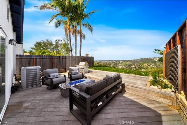wooden deck with central air condition unit, fence, and an outdoor hangout area