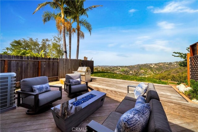 wooden deck featuring an outdoor living space with a fire pit, fence, and cooling unit
