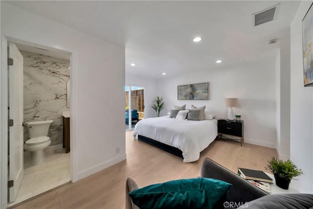 bedroom with visible vents, wood finished floors, baseboards, ensuite bathroom, and recessed lighting