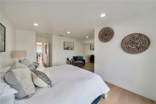 bedroom featuring light wood-style floors, baseboards, a closet, and recessed lighting