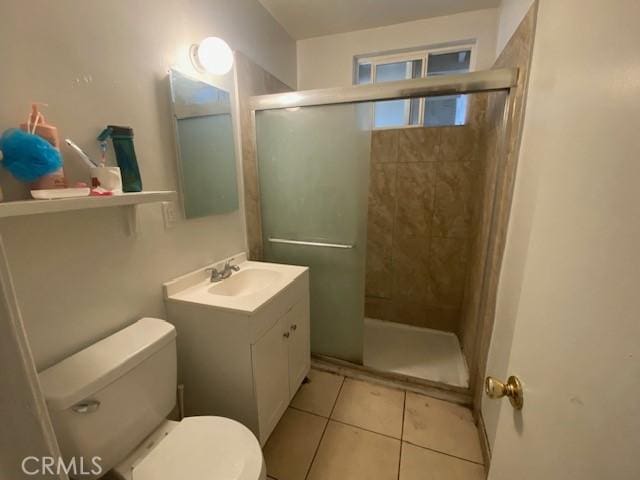 bathroom with vanity, toilet, a shower stall, and tile patterned flooring