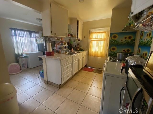 kitchen with light tile patterned floors, a wealth of natural light, and white cabinetry