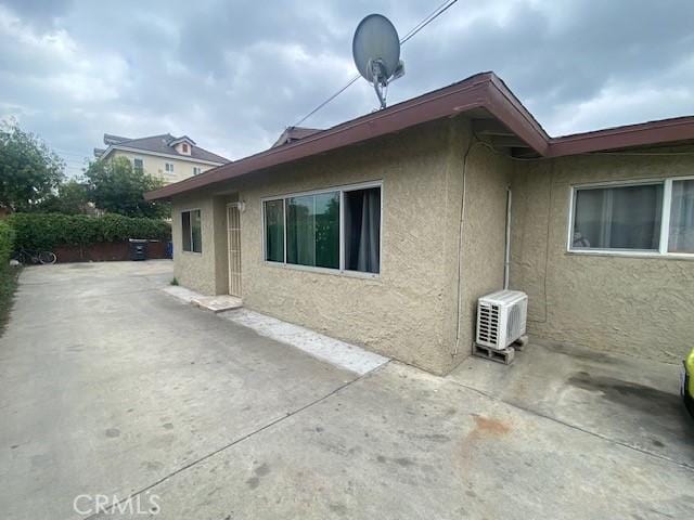 view of home's exterior featuring ac unit, stucco siding, and a patio area