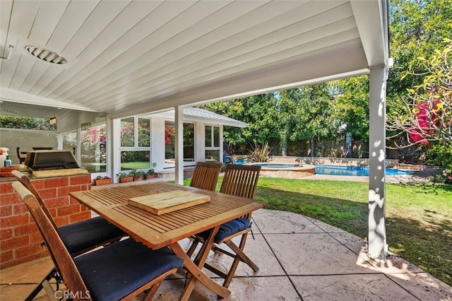 view of patio with outdoor dining space, grilling area, and a fenced in pool