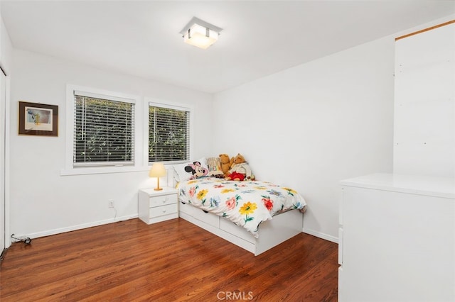 bedroom with baseboards and wood finished floors