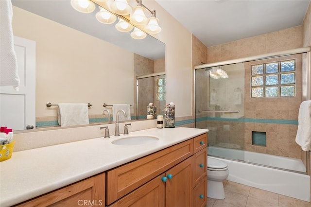 bathroom with toilet, shower / bath combination with glass door, tile patterned flooring, and vanity