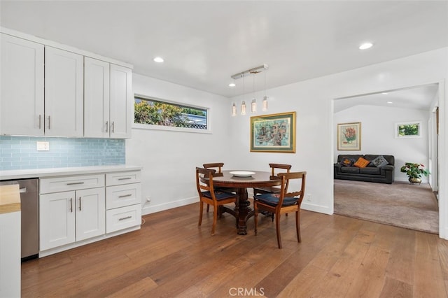 dining room with baseboards, wood-type flooring, and a healthy amount of sunlight