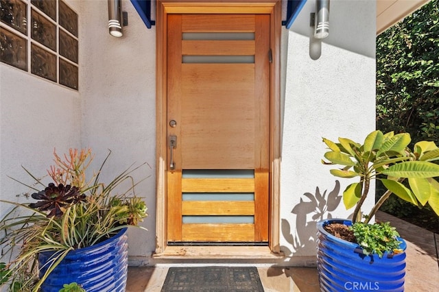 entrance to property featuring stucco siding