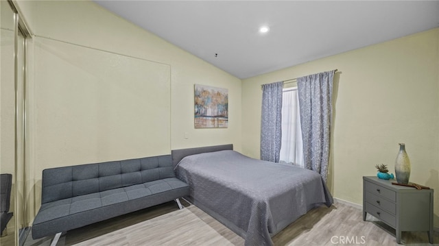 bedroom featuring lofted ceiling and light wood-style flooring